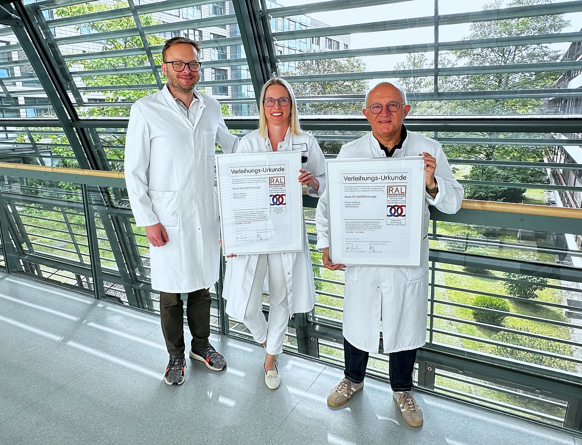 Drei Mitglieder der Gefäßchirurgie halten zwei RAL-Zertifizierungsurkunden.