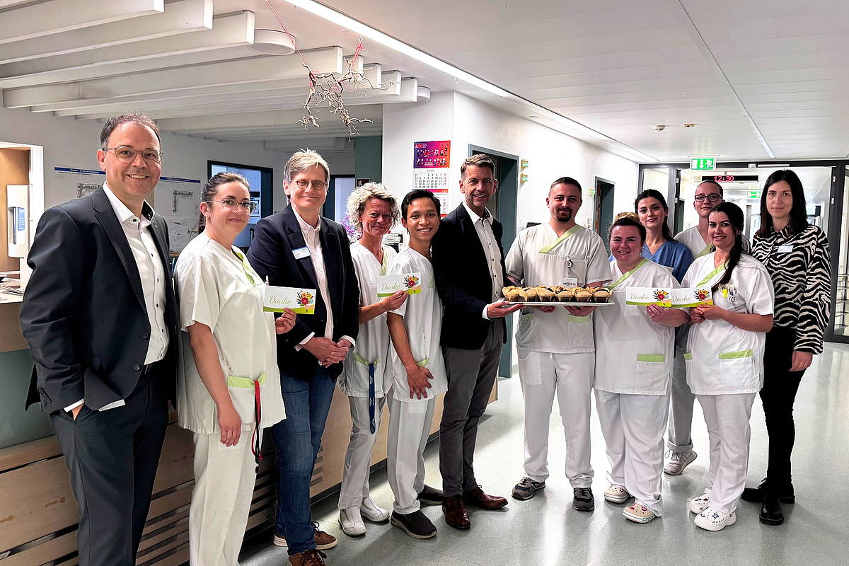 Beschäftigte der Station G6a mit Klinikleitung und Oberbürgermeister bei der Muffin-Übergabe.